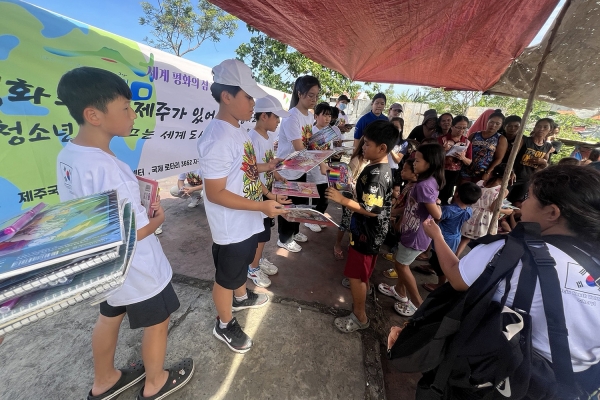 티나는제주 기자들이 필리핀 현지 어린이들에게 스케치북 등을 나눠주고 있다.